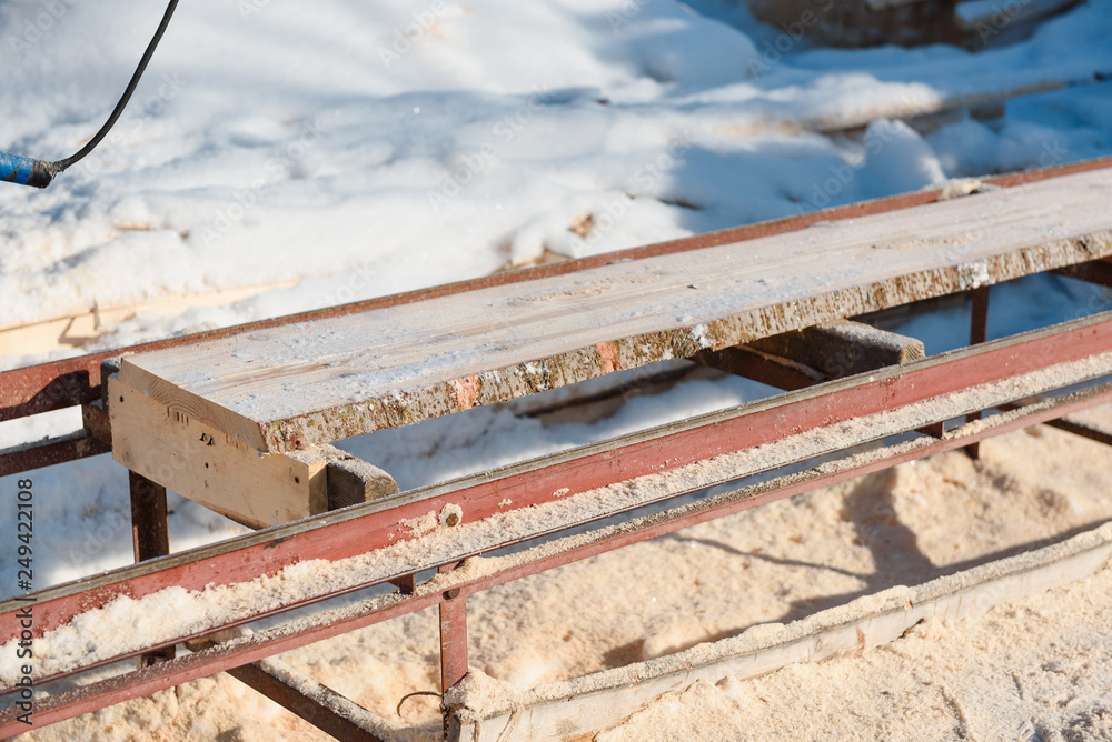 Sawing boards on the sawmill. Cook lumber in winter. Work on the sawmill. Sawing boards on the sawmill. Cook lumber in winter. Work on the sawmill.