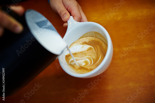 hand holding cup of coffee on black background