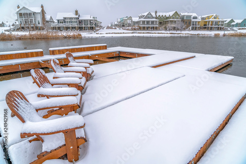 Lake deck with chairs covered with snow in winter