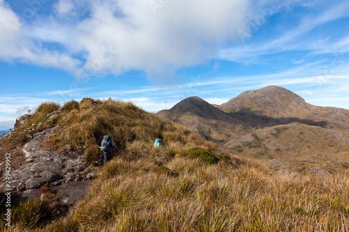 People walking with great backpacks in mountain landscape - trekking hiking mountaneering in mantiqueira range Brazil