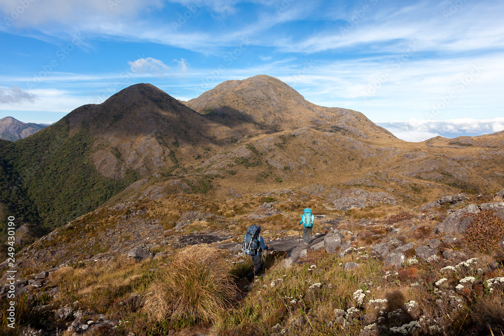 People walking with great backpacks in mountain landscape - trekking hiking mountaneering in mantiqueira range Brazil People walking with great backpacks in mountain landscape - trekking hiking mountaneering in mantiqueira range Brazil
