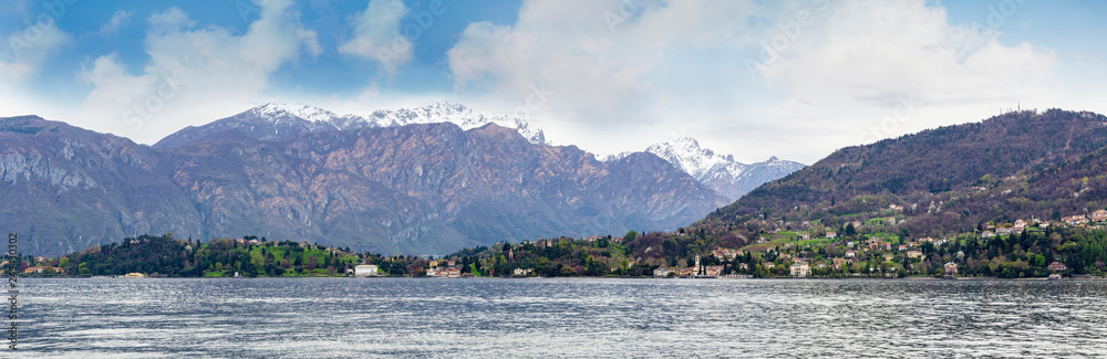 Bellagio villa in Como lake Italy with snow and mountain looking from boat i