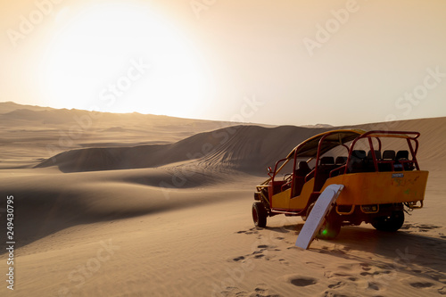 Canvastavla Sand boarding ,Dune Buggy parked in the desert during sunset at Huacachina Oasis in Ica, Peru