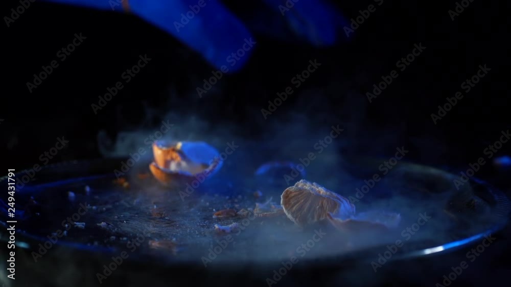 nitrogenfrozen mandarin is broken with a hammer in laboratory by