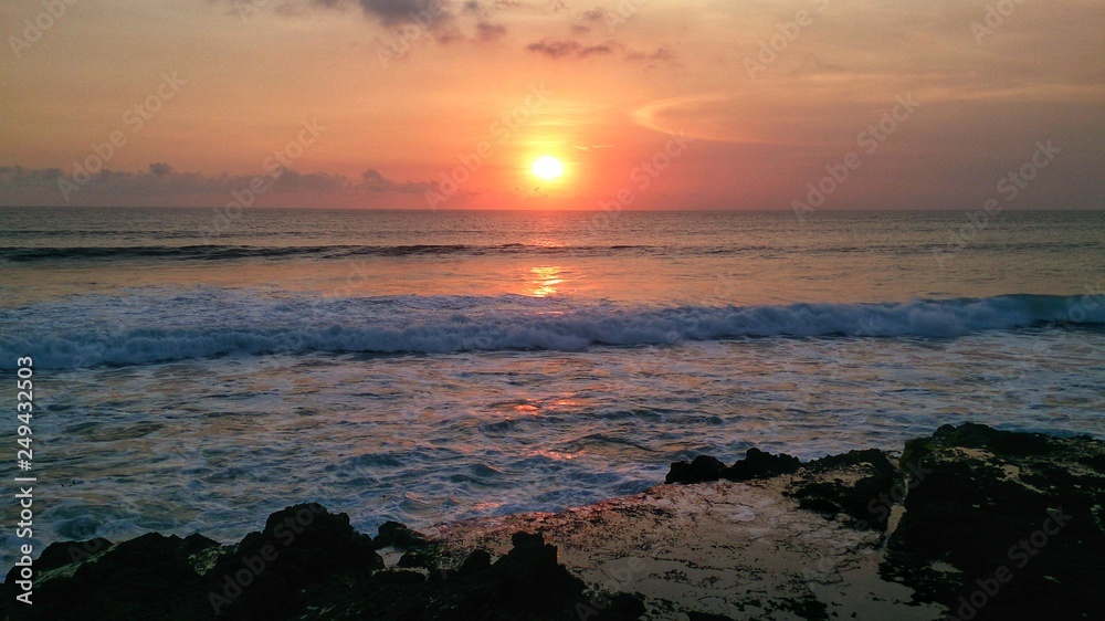 Beautiful Sunset at the ocean beach with wave and coral Beautiful Sunset at the ocean beach with wave and coral