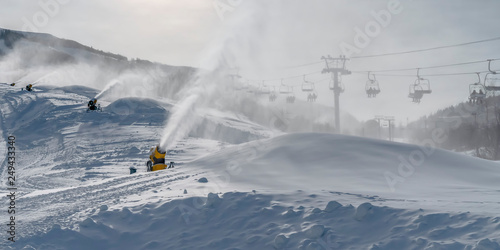 Foto Snow guns and ski lifts on snow covered mountain