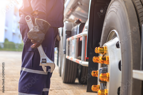 Mechanic with Large Wrench in Hand Taking Look at on the Truck,Concept truck maintenance,spot focus.
