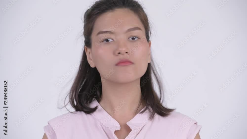 Face of young serious Asian businesswoman nodding head no Face of young serious Asian businesswoman nodding head no