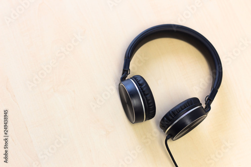 Black headphones on wooden table background