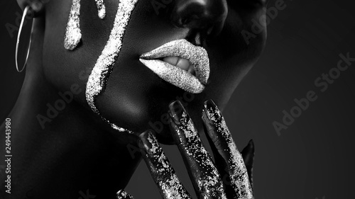 Young woman face with art fashion makeup. An amazing model with creative makeup. Black and white closeup portrait