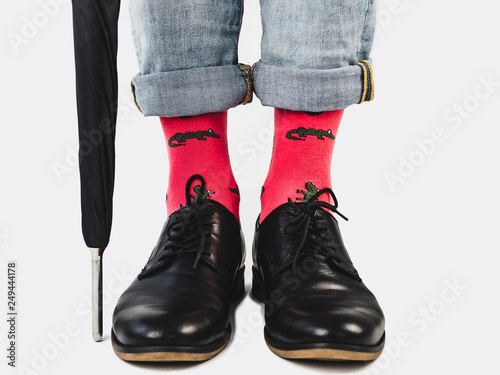 Office Manager in stylish shoes, blue pants and bright, colorful socks on a white, isolated background. Close-up. Lifestyle, fashion, fun, elegance