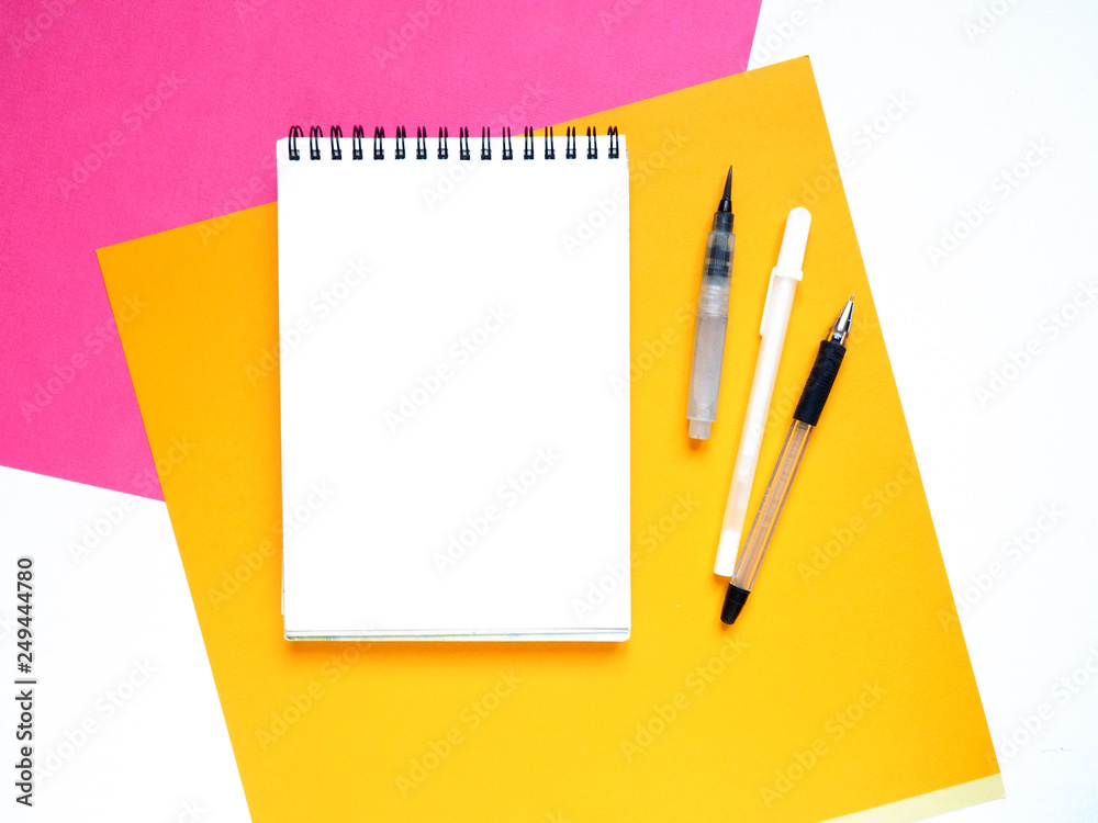 Art table colorful sheets of paper and blank notebook on white background Art table colorful sheets of paper and blank notebook on white background