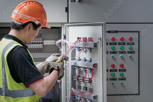 Electrician young people working with wires in the control room of plant. photo