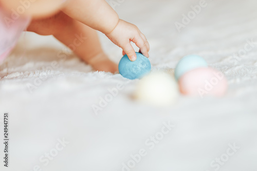Cute little baby girl, playing with colorful easter eggs