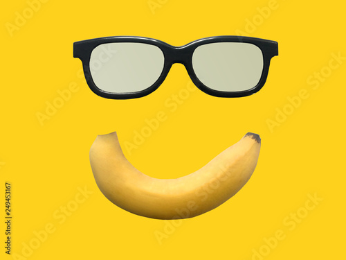 Cavendish yellow banana smile face with vintage glasses isolated on yellow background.