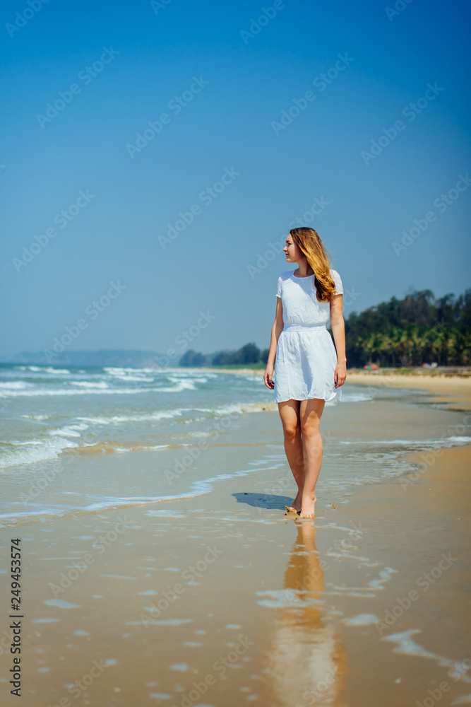 Beautiful Girl in White Dress Enjoy and Relax on The Beach. Travel and Vacation. Beautiful Girl in White Dress Enjoy and Relax on The Beach. Travel and Vacation.