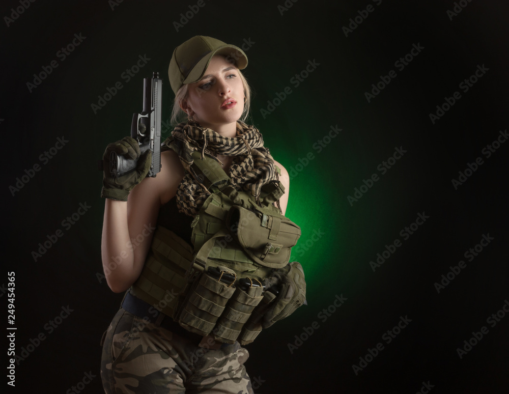 girl in military special clothes posing with a gun in his hands on a dark background in the haze girl in military special clothes posing with a gun in his hands on a dark background in the haze