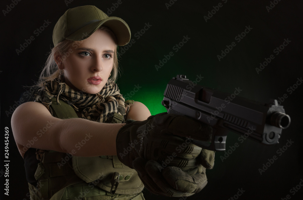 girl in military special clothes posing with a gun in his hands on a dark background in the haze girl in military special clothes posing with a gun in his hands on a dark background in the haze