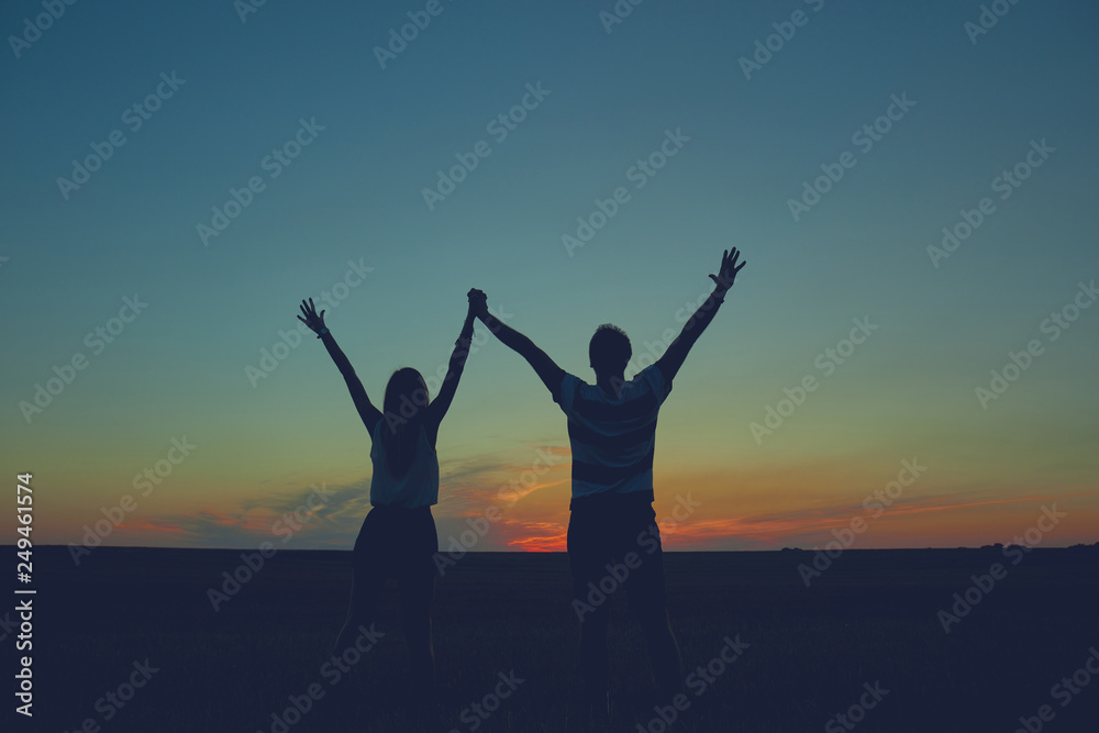 Fototapeta premium Silhouettes of a couple in sunset / sunrise time.