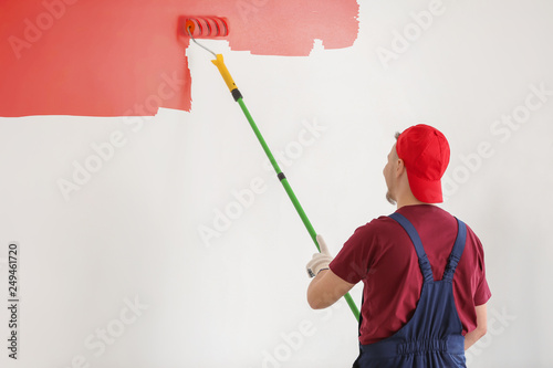 Male painter in uniform wor...