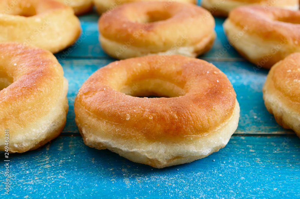 Homemade classic donuts on a blue wooden table. Close up. Homemade classic donuts on a blue wooden table. Close up.