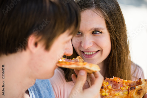 Close-up shot of a couple eating pizza