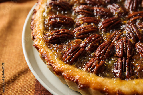 Plate with tasty pecan pie on table, closeup photo