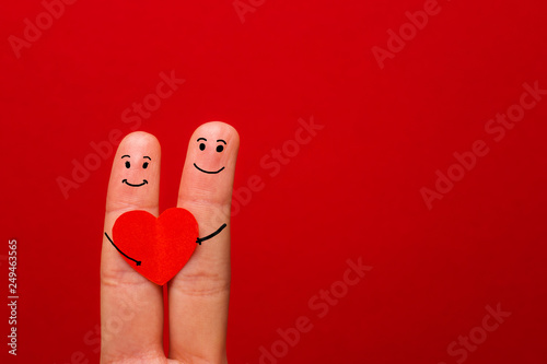 Happy couple in love with painted smiley holding red heart - Image.