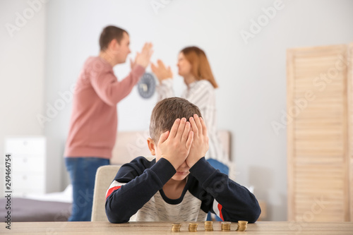 Sad little boy with coins a...