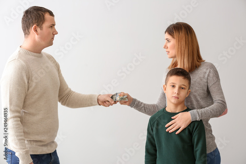 Man giving alimony to his ex-family on light background