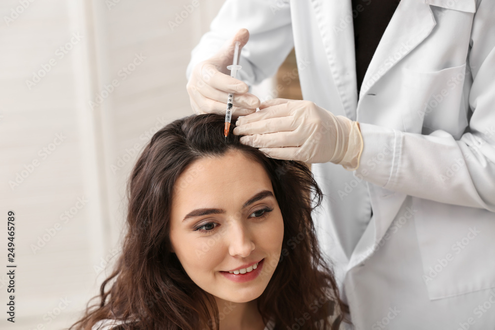 Woman with hair loss problem receiving injection in clinic Woman with hair loss problem receiving injection in clinic