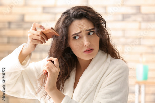Woman with hair loss problem in bathroom