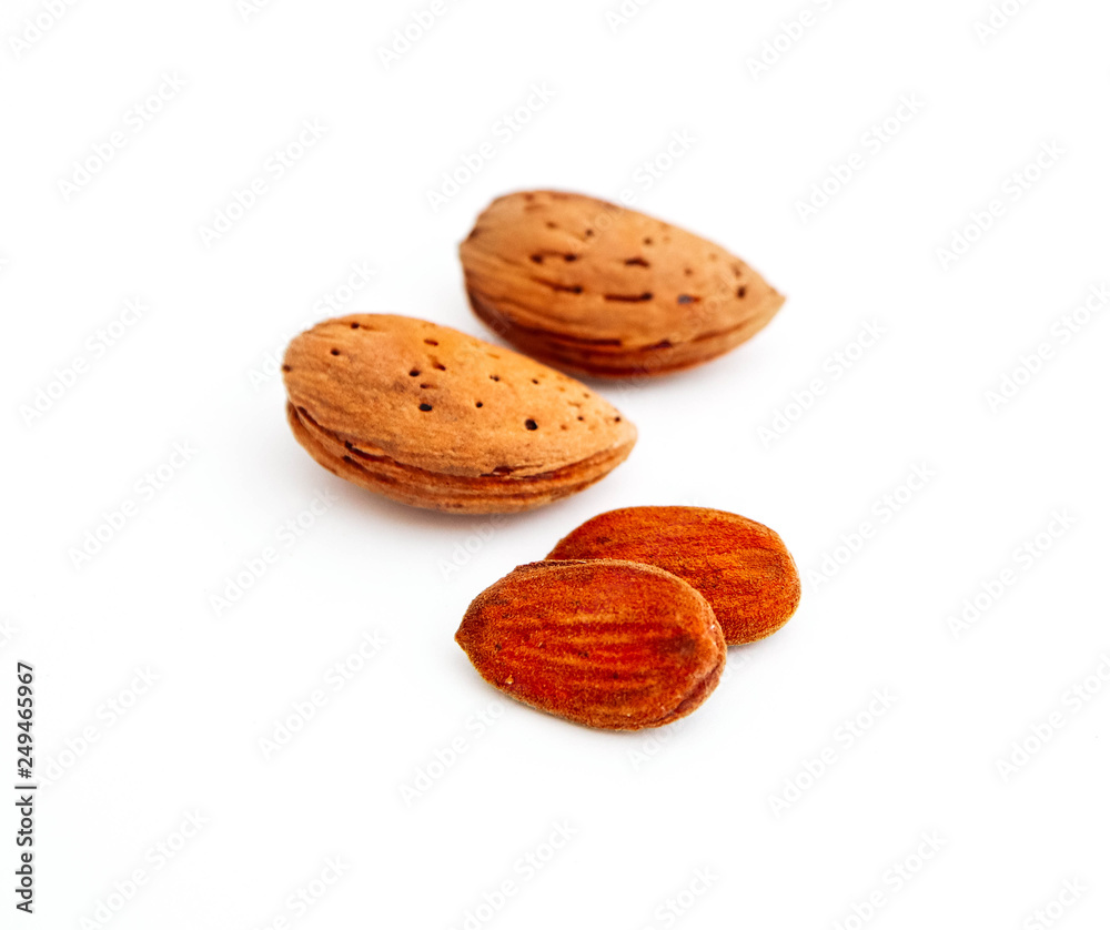 A pile of wild peeled almond nuts and kernels, closeup, isolated on white background. A pile of wild peeled almond nuts and kernels, closeup, isolated on white background.