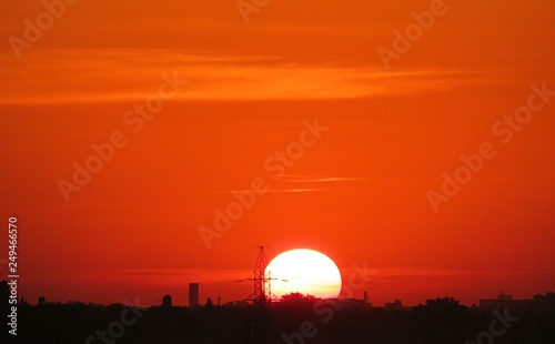 Beautiful fiery orange sunset in the sky, the sun sets over the horizon 