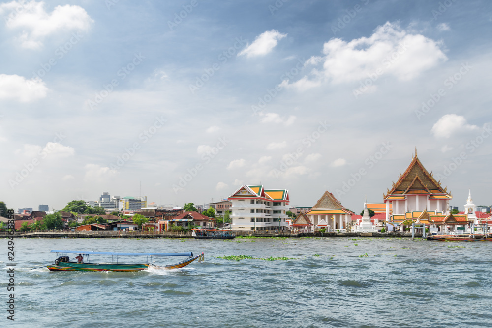 Boat sailing along the Chao Phraya River in Bangkok, Thailand