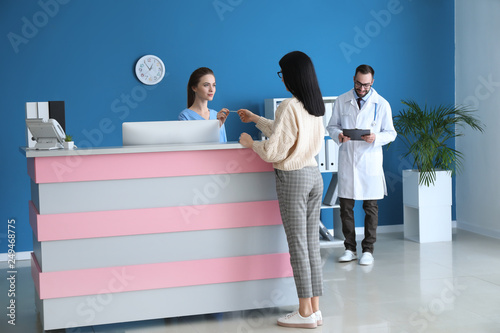 Female receptionist receivi...