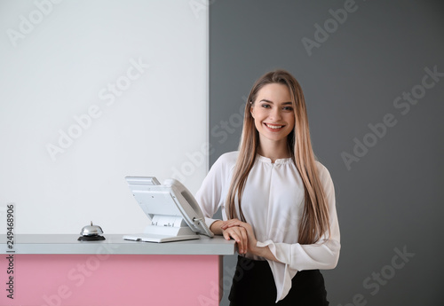 Canvas Print Female receptionist near desk in hotel