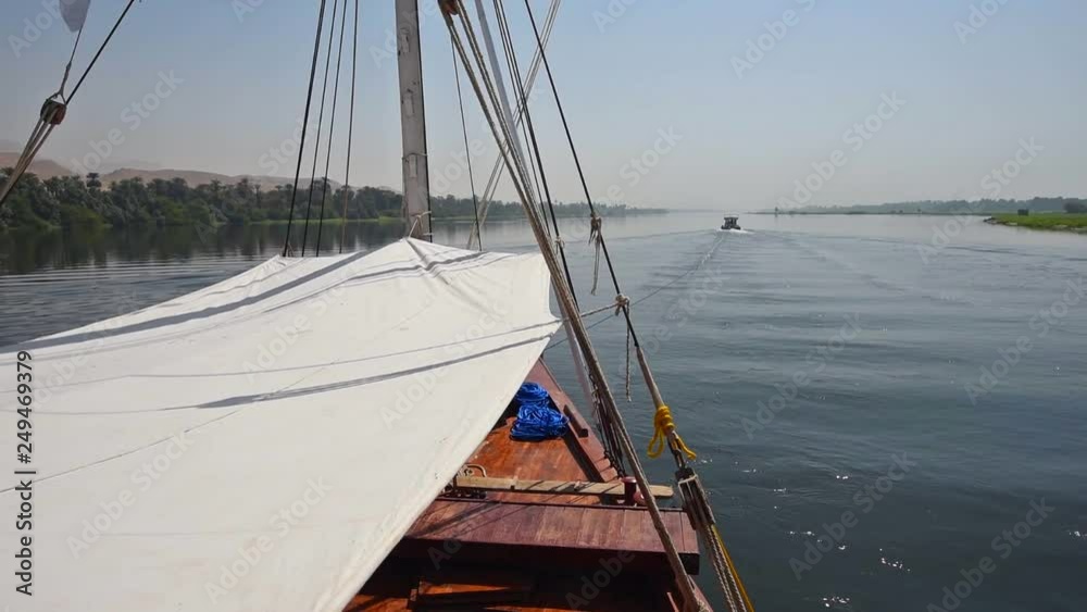 View across large wide river Nile in Egypt to riverbank through rural countryside landscape from luxury sailing cruise boat View across large wide river Nile in Egypt to riverbank through rural countryside landscape from luxury sailing cruise boat