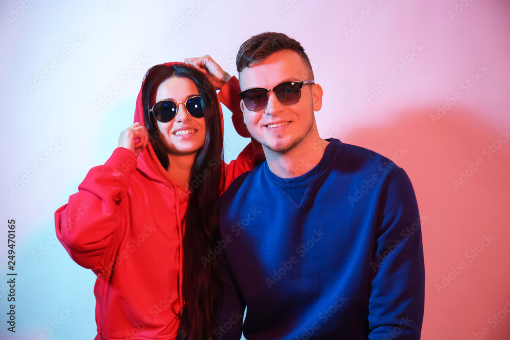Toned portrait of stylish young couple on light background Toned portrait of stylish young couple on light background
