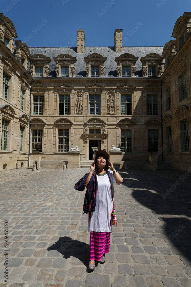 Femme posant dans la cour l'hötel de Sully à Paris