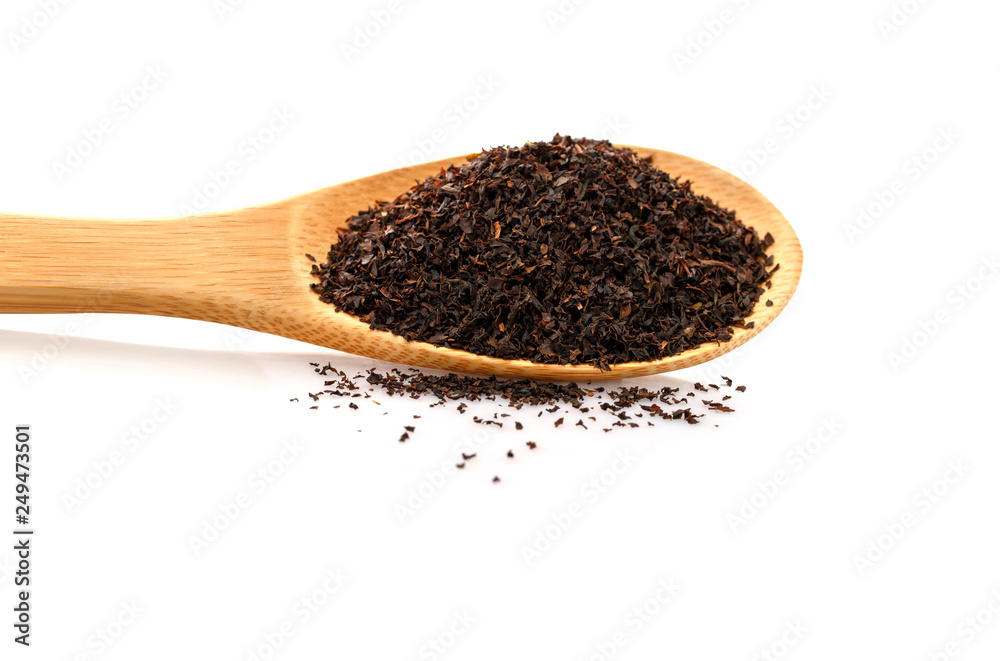Black tea in a wooden spoon. Large leaf tea. Isolated on white background. Black tea in a wooden spoon. Large leaf tea. Isolated on white background.