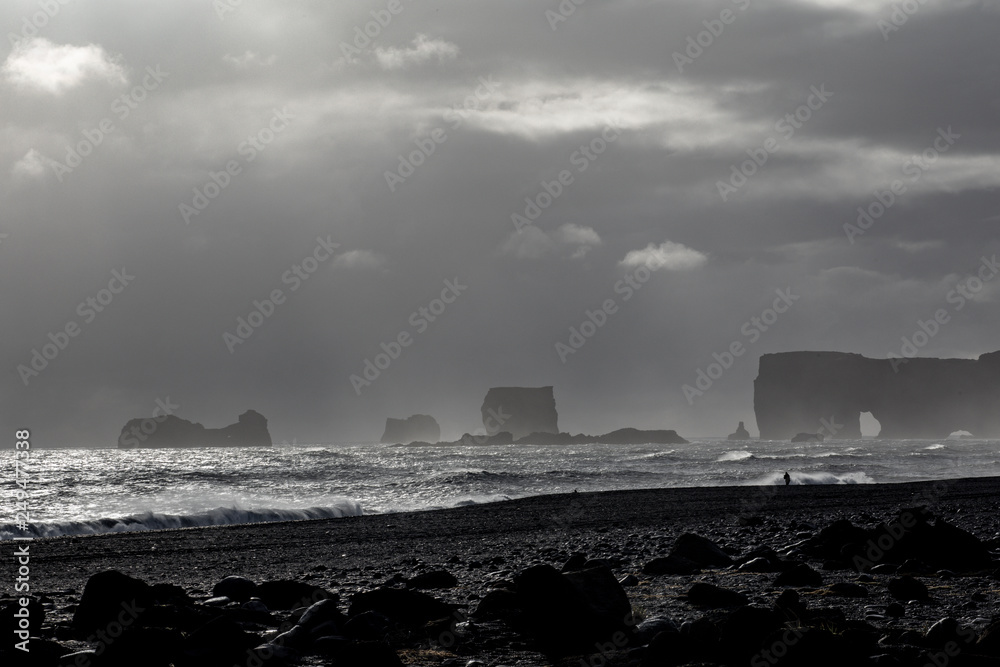 Famous basalt sea stacks of Reynisdrangar, rock formations on the black sand of Reynisfjar beach, view not far from Vik, a small village in southern Iceland. Troll Fingers