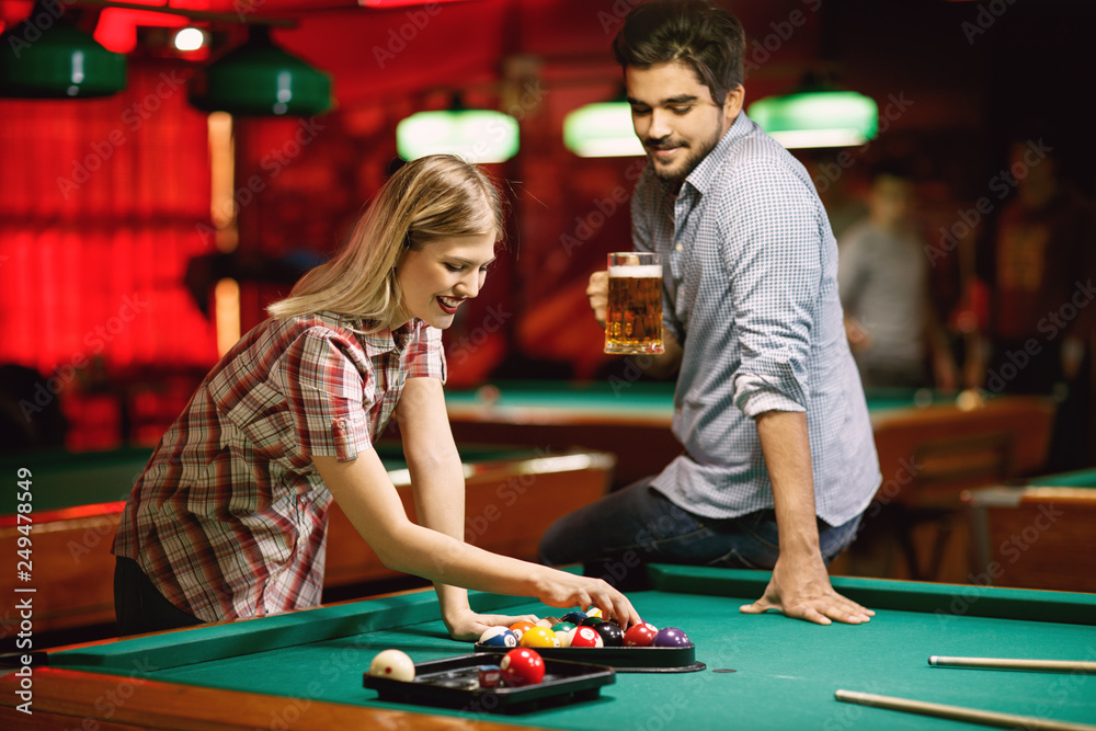 billiard - Young couple sorting balls for beginning game. billiard - Young couple sorting balls for beginning game.