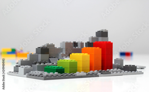 Progress chart made of bricks. Isometric composition of colourful toys on white table.