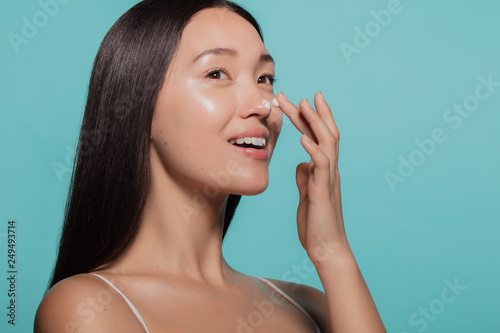 Billede på lærred Dazzling woman applying moisturizing cream