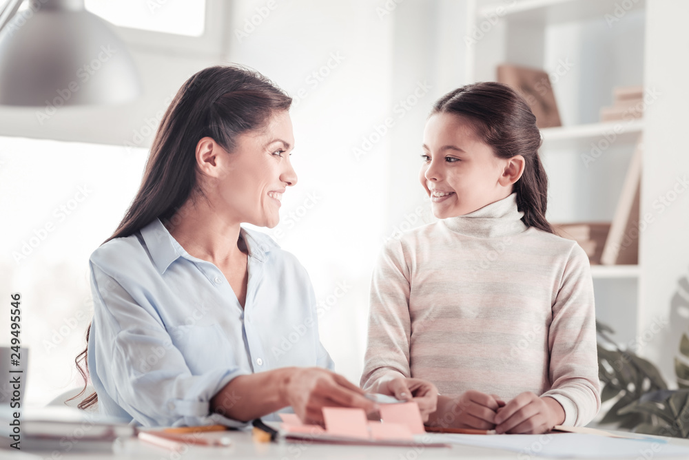 Well-behaved glad daughter helping mother with work Well-behaved glad daughter helping mother with work