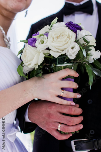 wedding bouquet in hands of bride and groom