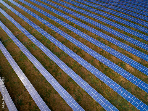 Aerial drone view of solar panels at a solar energy generation farm at Sunset in South Wales, UK