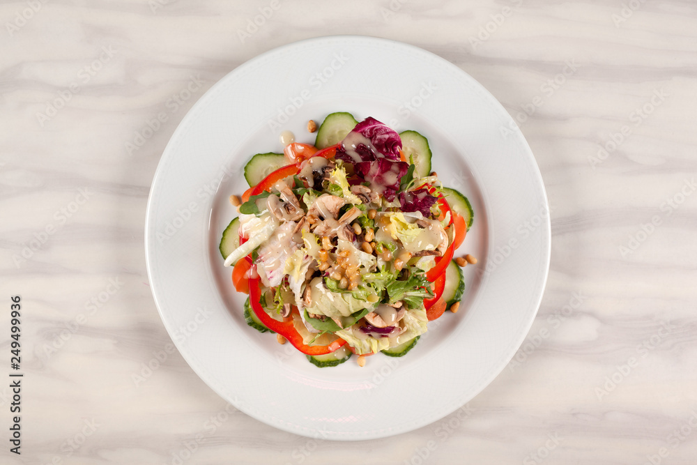 Vegetable salad with corn and mushrooms on a white plate on the table. Vegetable salad with corn and mushrooms on a white plate on the table.