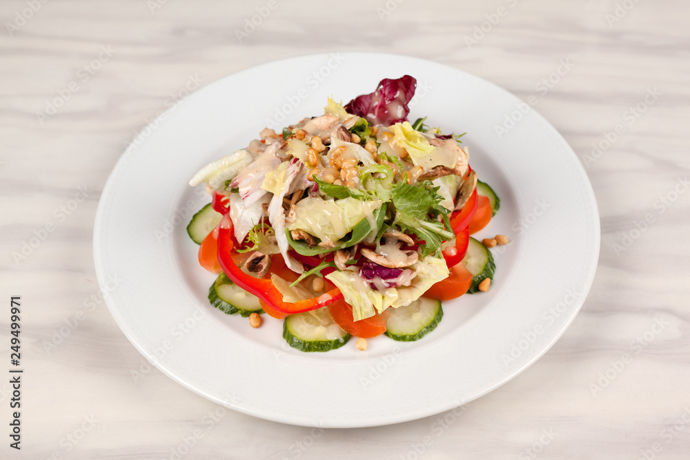 Vegetable salad with corn and mushrooms on a white plate on the table. Vegetable salad with corn and mushrooms on a white plate on the table.